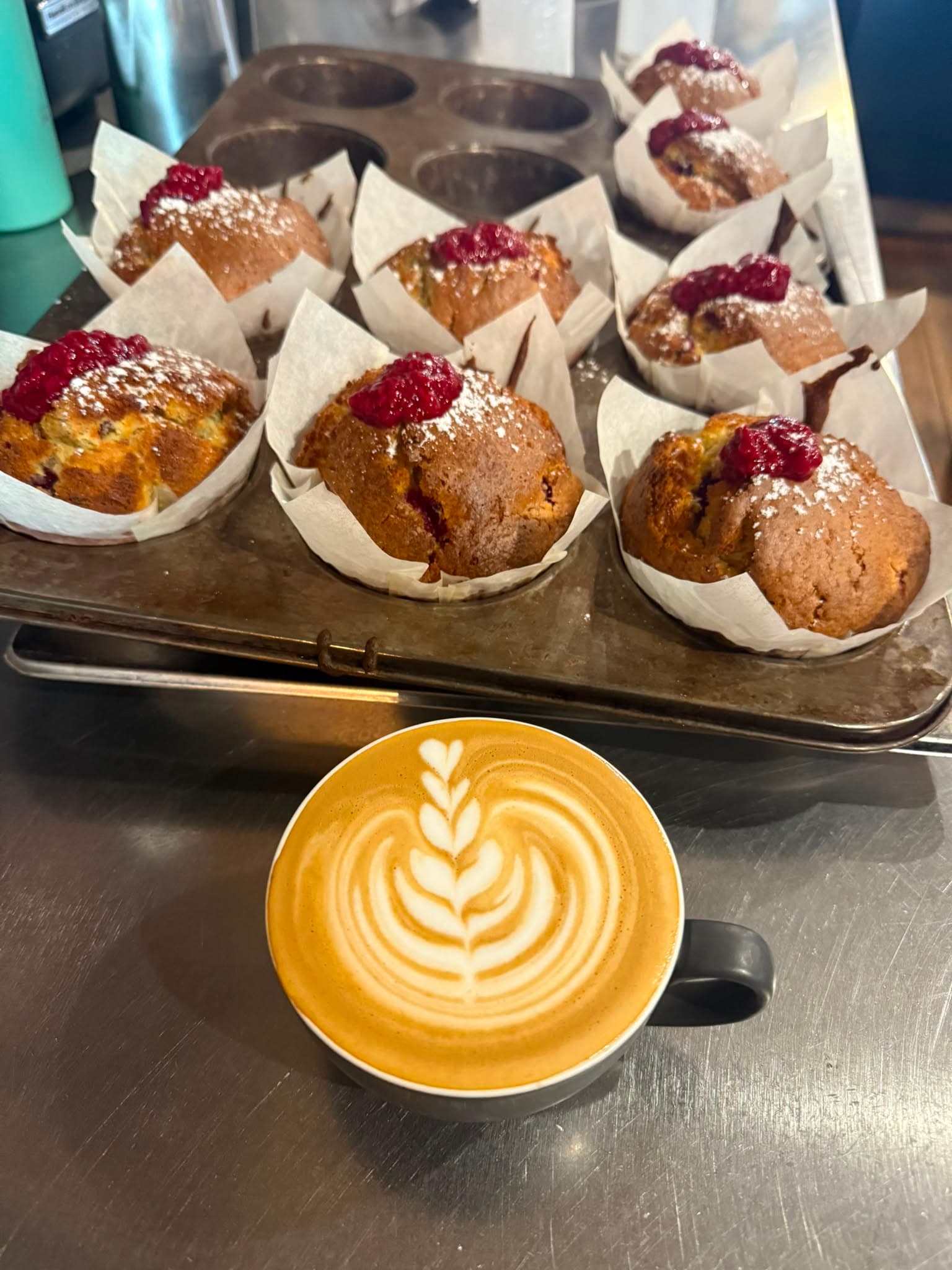 A flat white coffee served alongside a slice of homemade cake